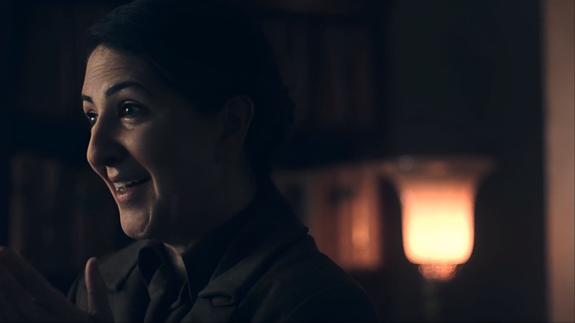 With quiet intensity, Aunt Phoebe listens closely, her motives hidden beneath politeness in The Handmaid's Tale. (Image via Hulu)