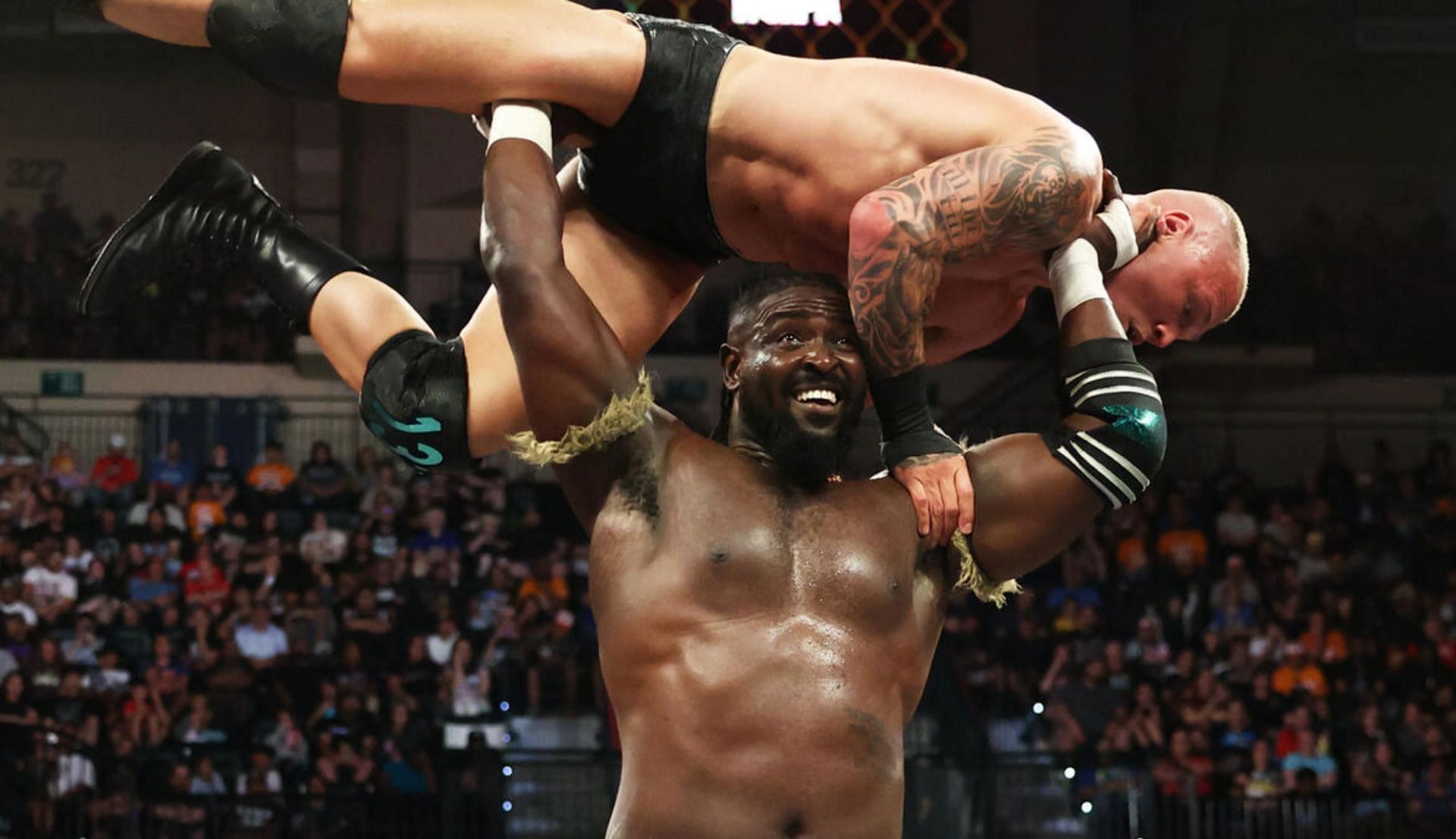 ओबा फेमी, माइल्स बोर्न को उठाते हुए (Photo: WWE.com)