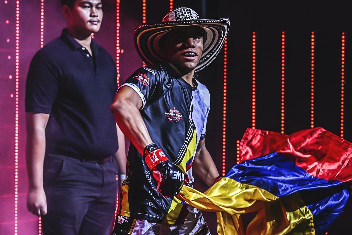 Johan Estupinan in a hat, holding the Colombian flag