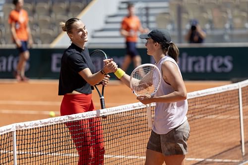 Iga Swiatek (R) and Aryna Sabalenka share a light moment after a training session ahead of the 2025 French Open. Source: Getty
