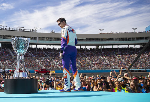 Denny Hamlin stands next to the Bill France Cup trophy at Phoenix Raceway. Source: Imagn