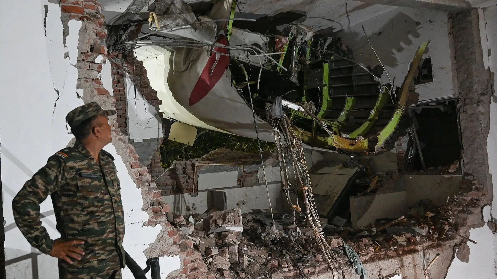 Rescue personnel looking at the wreckage at the site of the Air India flight crash (Image via Getty)