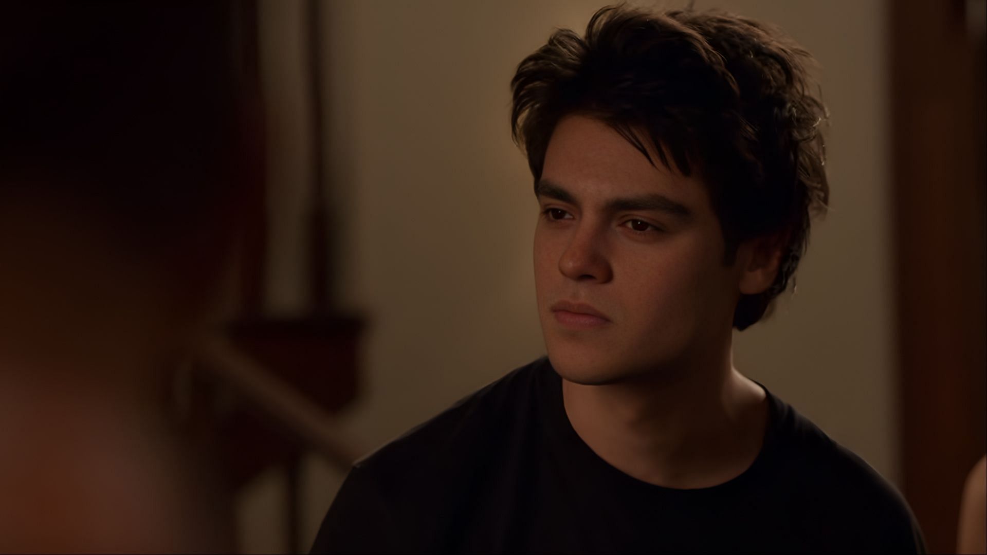 Marcus Baker sits indoors with a tired expression, showing signs of emotional exhaustion in Ginny &amp; Georgia season 3.