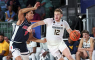 Tucker DeVries (#12) drives to the basket as Arizona Wildcats forward Carter Bryant (#9) defends during the second half at Imperial Arena at the Atlantis resort. Photo: Imagn