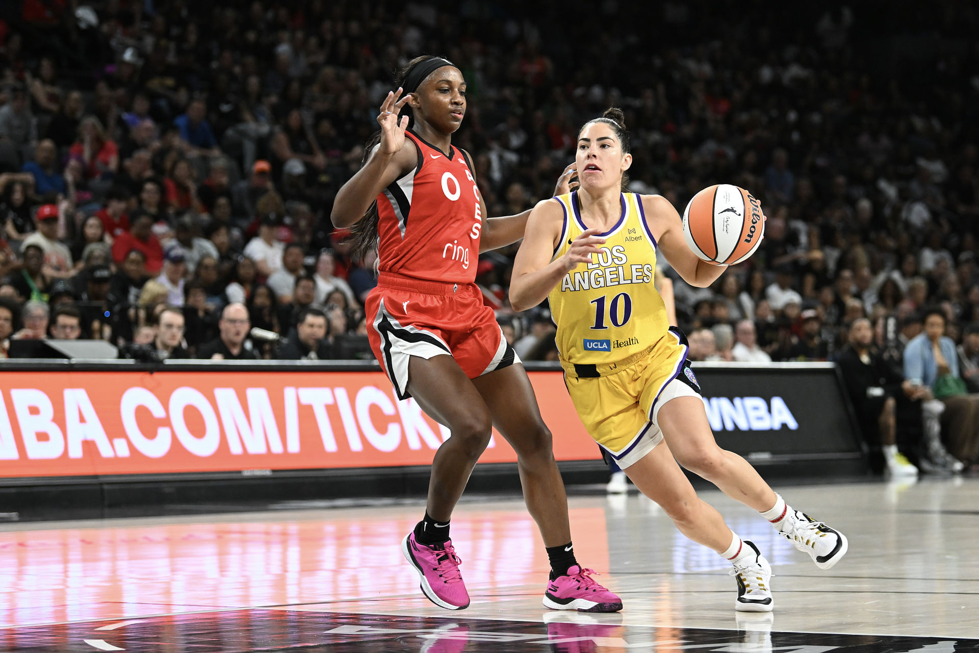May 30, 2025; Las Vegas, Nevada, USA; Los Angeles Sparks guard Kelsey Plum (10) drives past Las Vegas Aces guard Jackie Young (0) in the fourth quarter of their game at Michelob Ultra Arena. Mandatory Credit: Candice Ward-Imagn Images - Source: Imagn