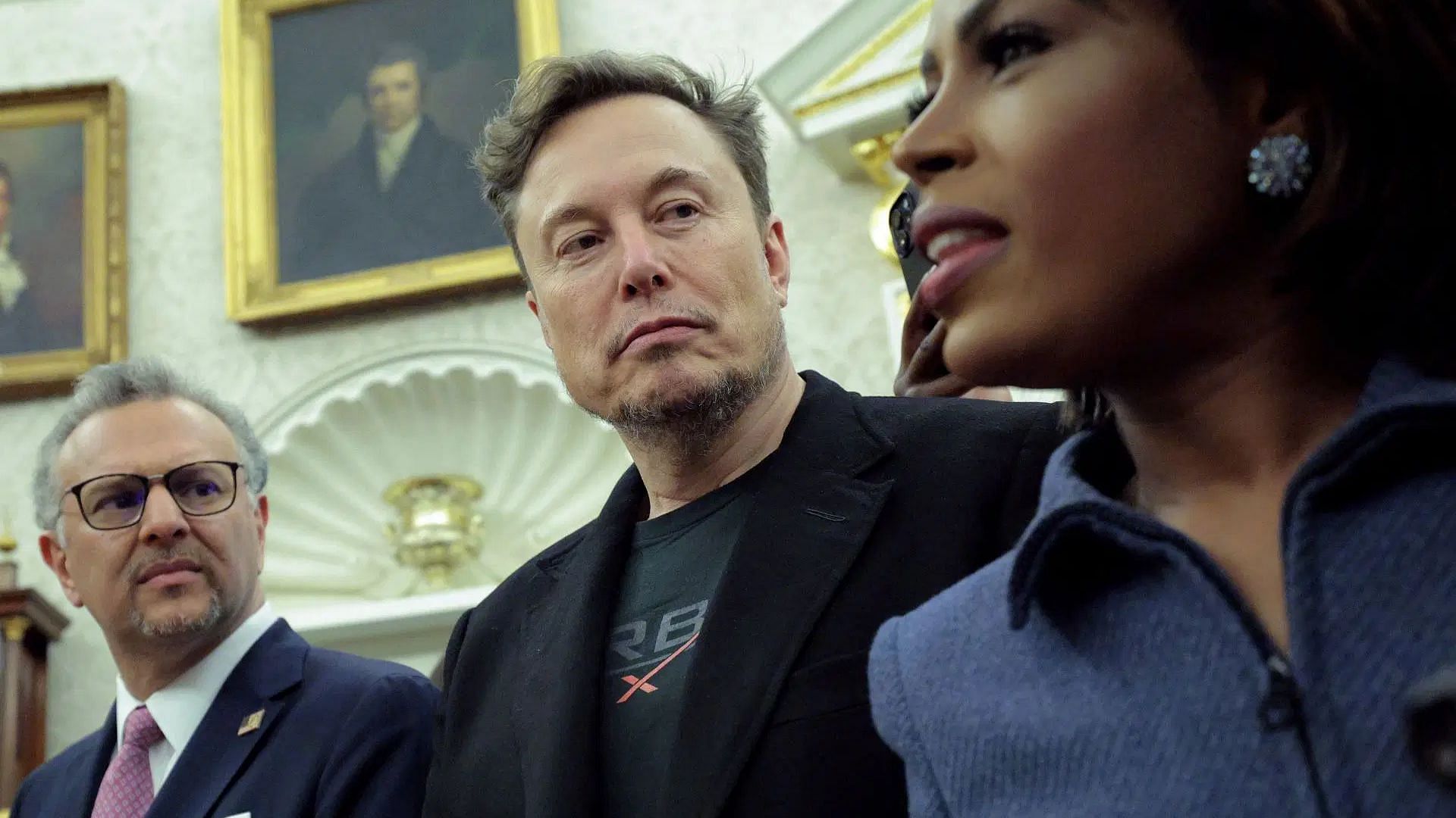 Tesla CEO Elon Musk (C) looks on during a meeting between President of South Africa Cyril Ramaphosa and U.S. President Donald Trump (Image via Getty)