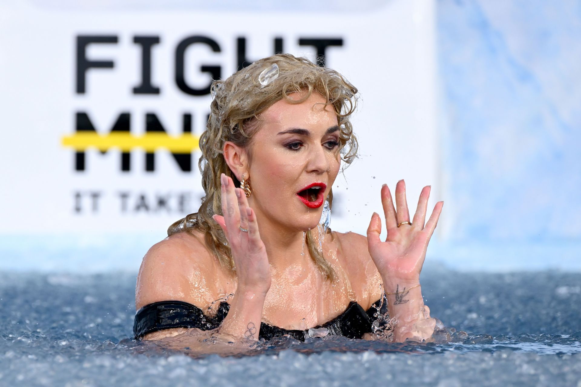 Ariarne Titmus dons new attire as Olivia Newton-John for icy plunge at AFL