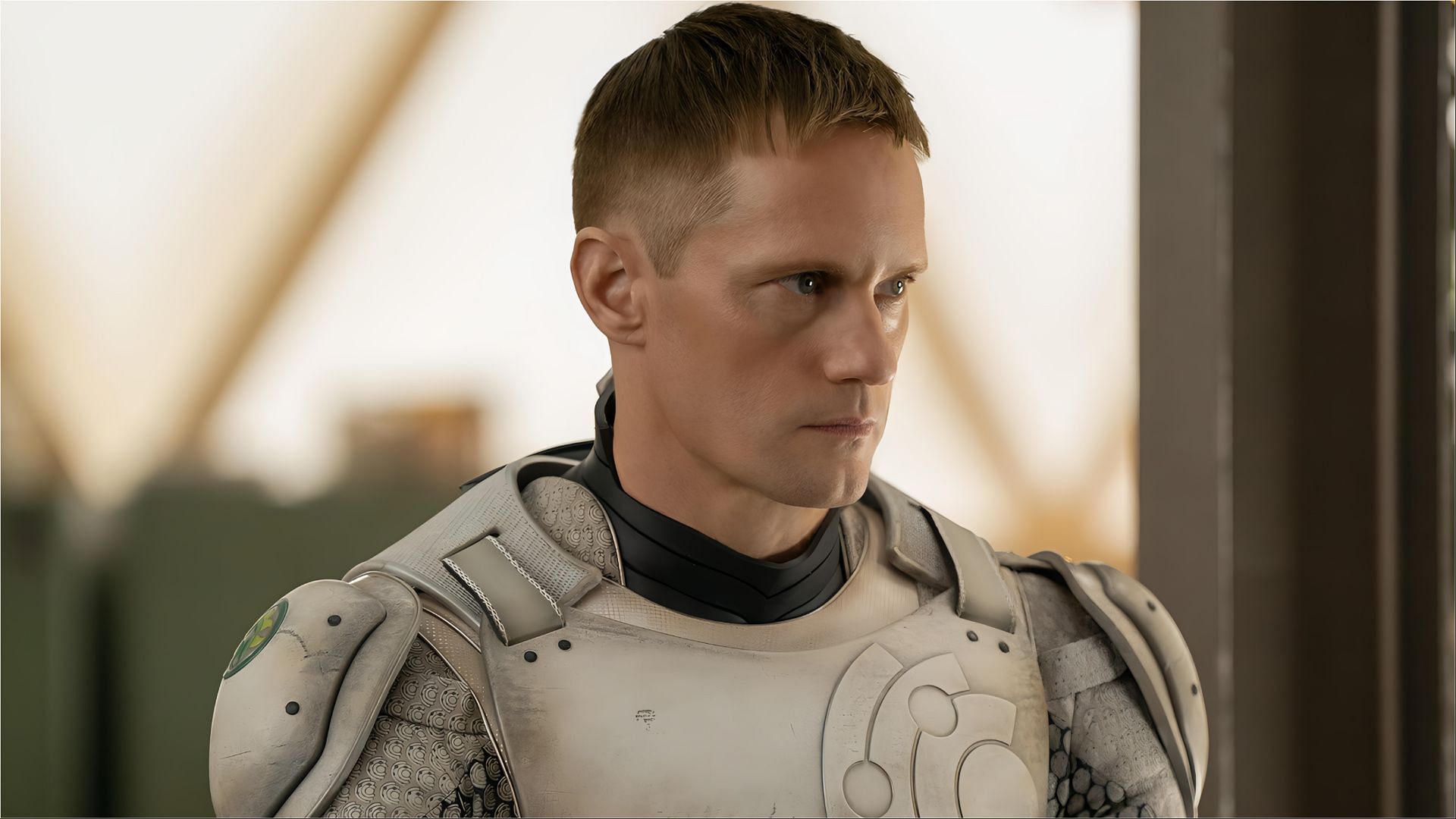 Alexander Skarsg&aring;rd in character as a cyborg wearing futuristic armor, looking serious and focused.