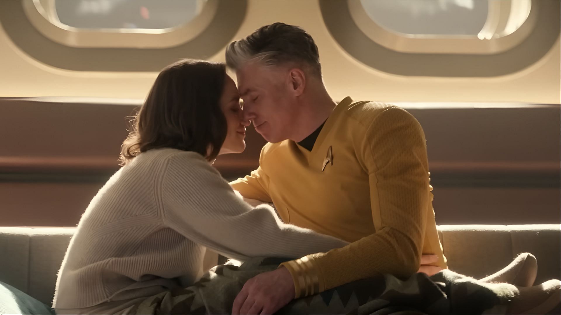  Captain Pike and Marie Batel sit close together, touching foreheads affectionately aboard the Enterprise in Star Trek: Strange New Worlds season 3.