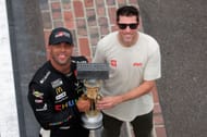 Bubba Wallace (L) and co-owner of 23XI Racing, Denny Hamlin, pose with the Brickyard 400 trophy at the yard of bricks after winning the NASCAR Cup Series Brickyard 400- Source: Getty