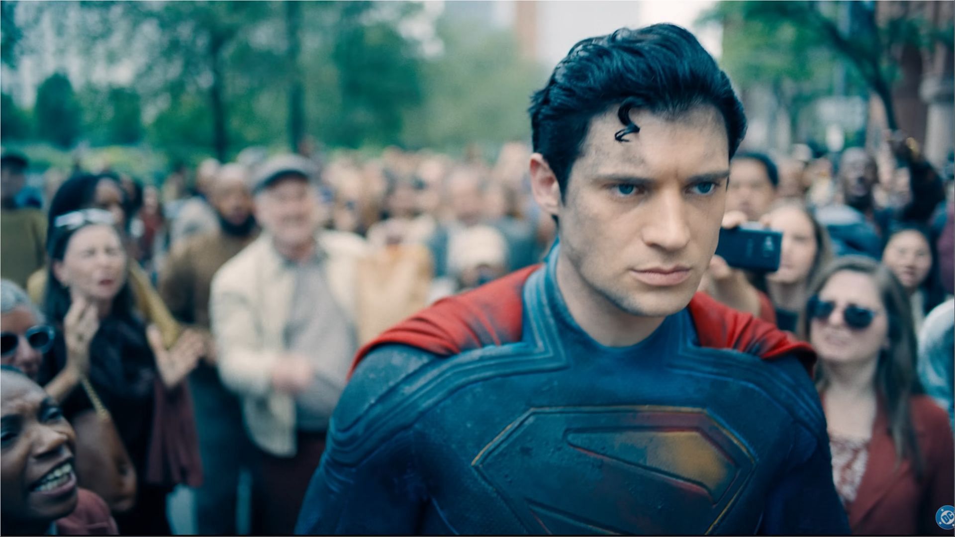 David Corenswet in Superman costume walking through a crowd in Superman (2025), with a determined expression.