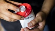 An American football player holds creatine at a gym (Image via Getty)