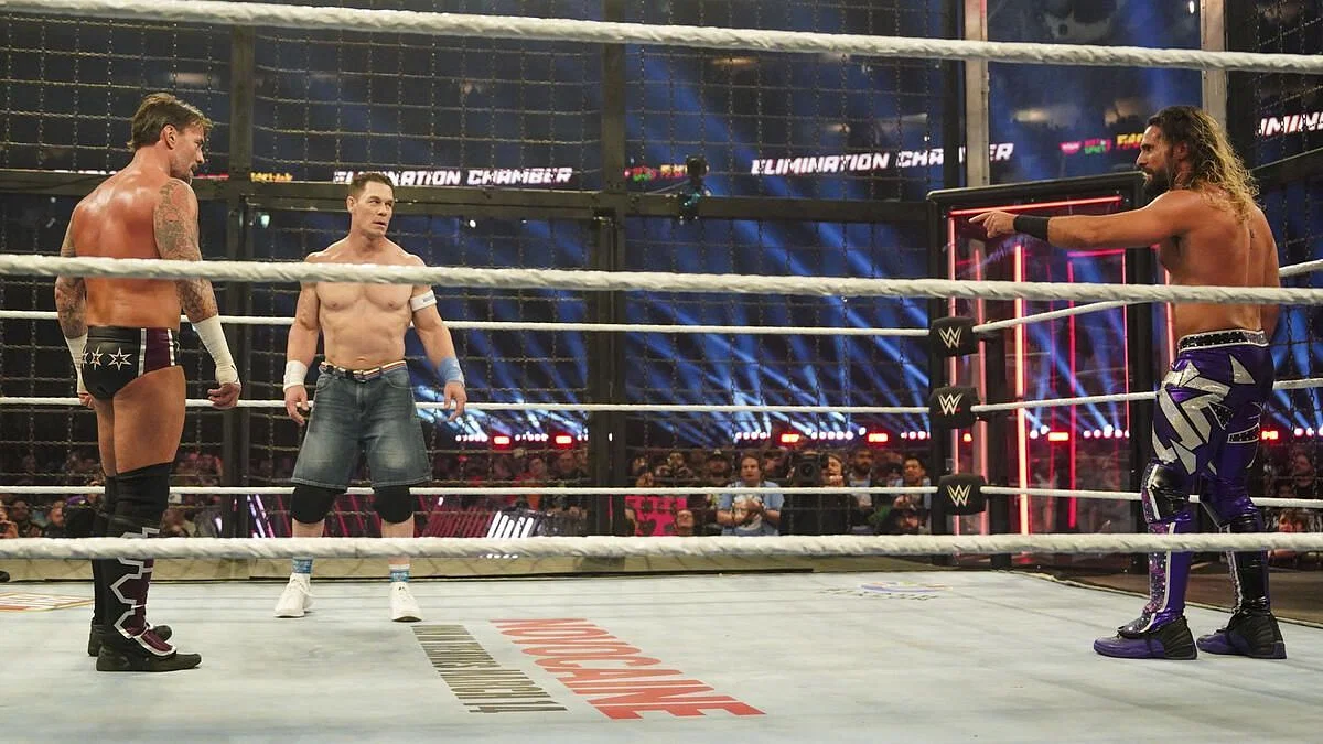 CM Punk, John Cena, and Seth Rollins inside the Elimination Chamber. (Photo credit: WWE.com)