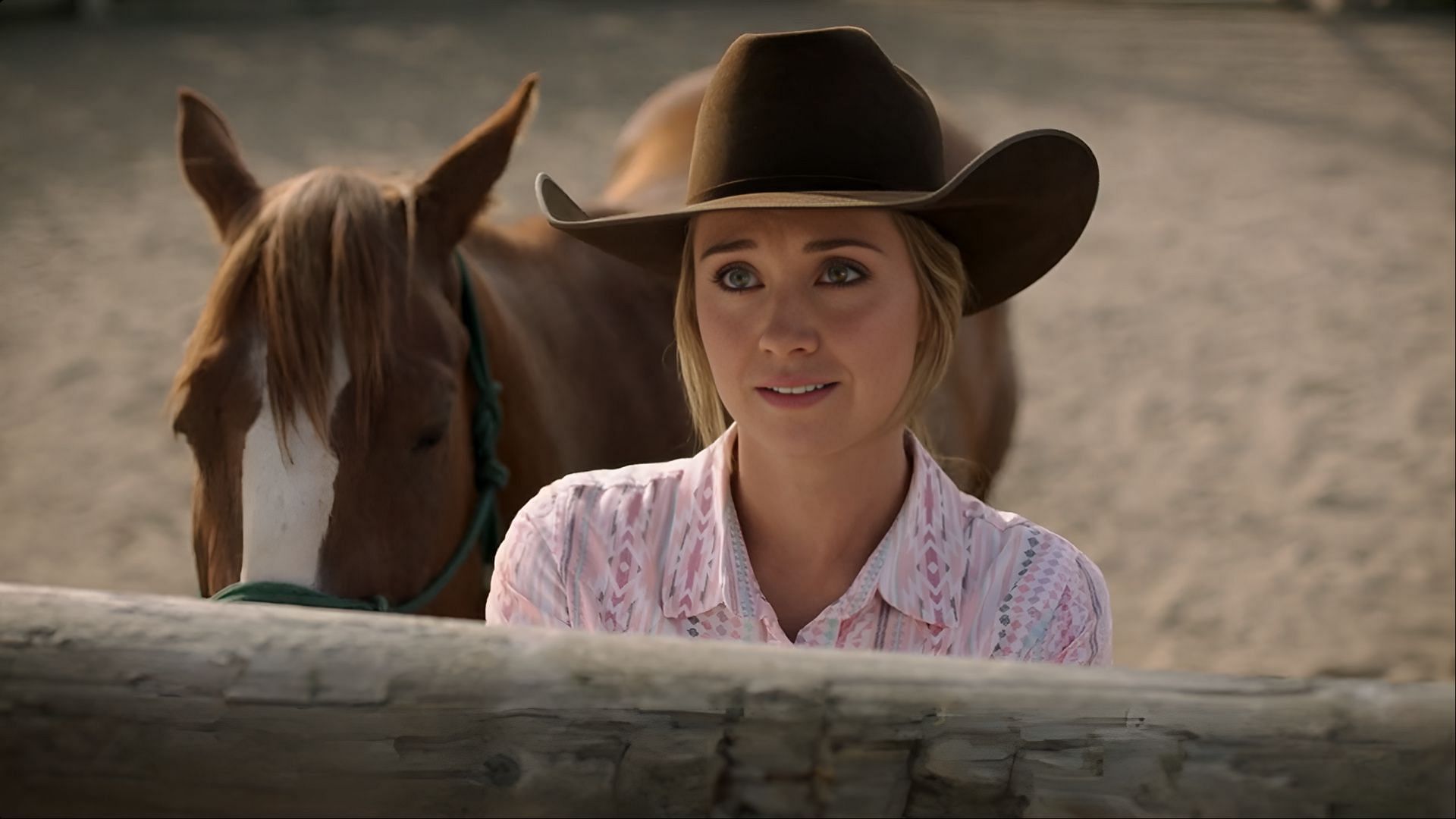  Amy Fleming from Heartland standing next to a horse inside the ranch.