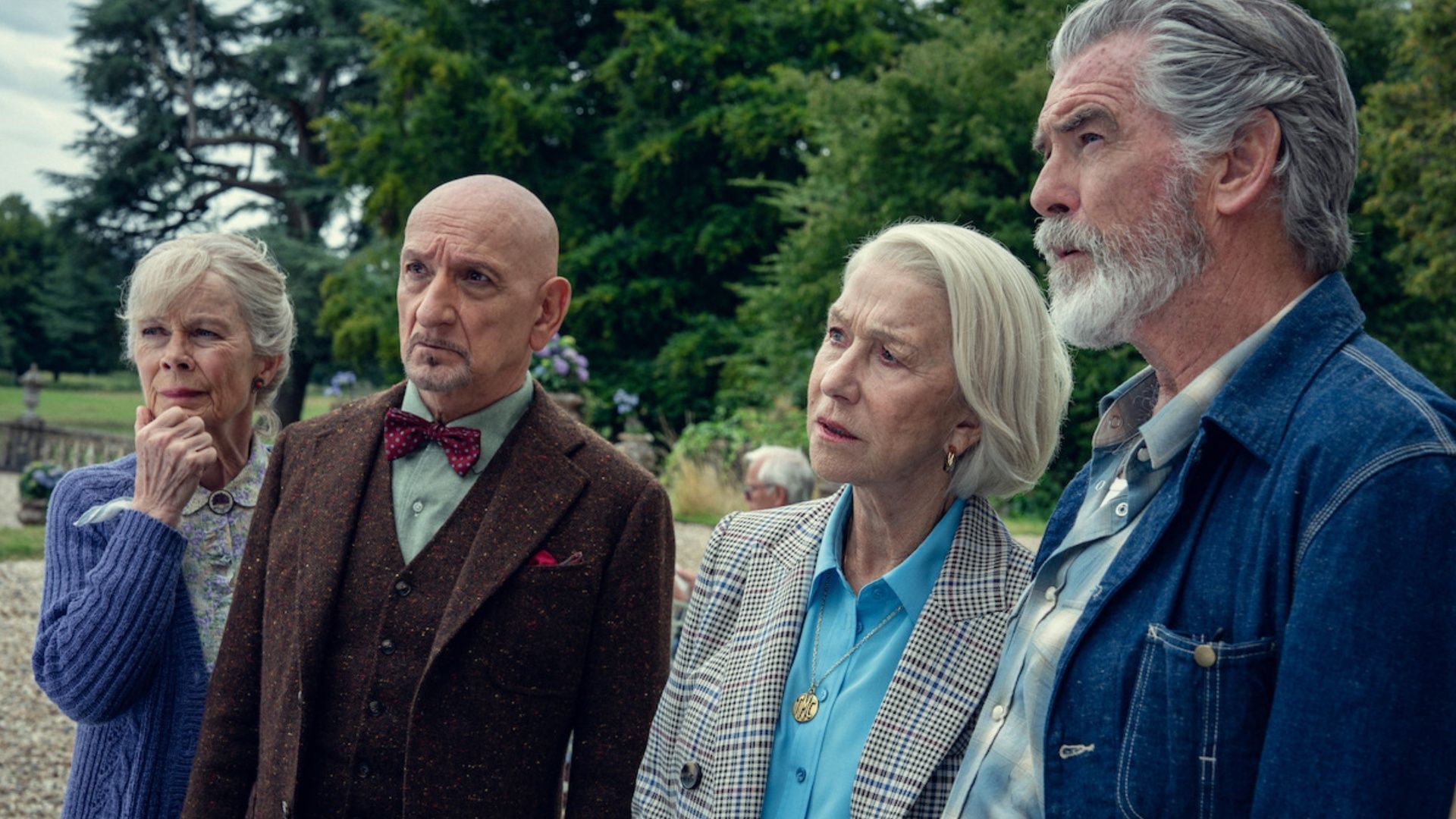 Four elderly friends stand outdoors, looking concerned and focused.