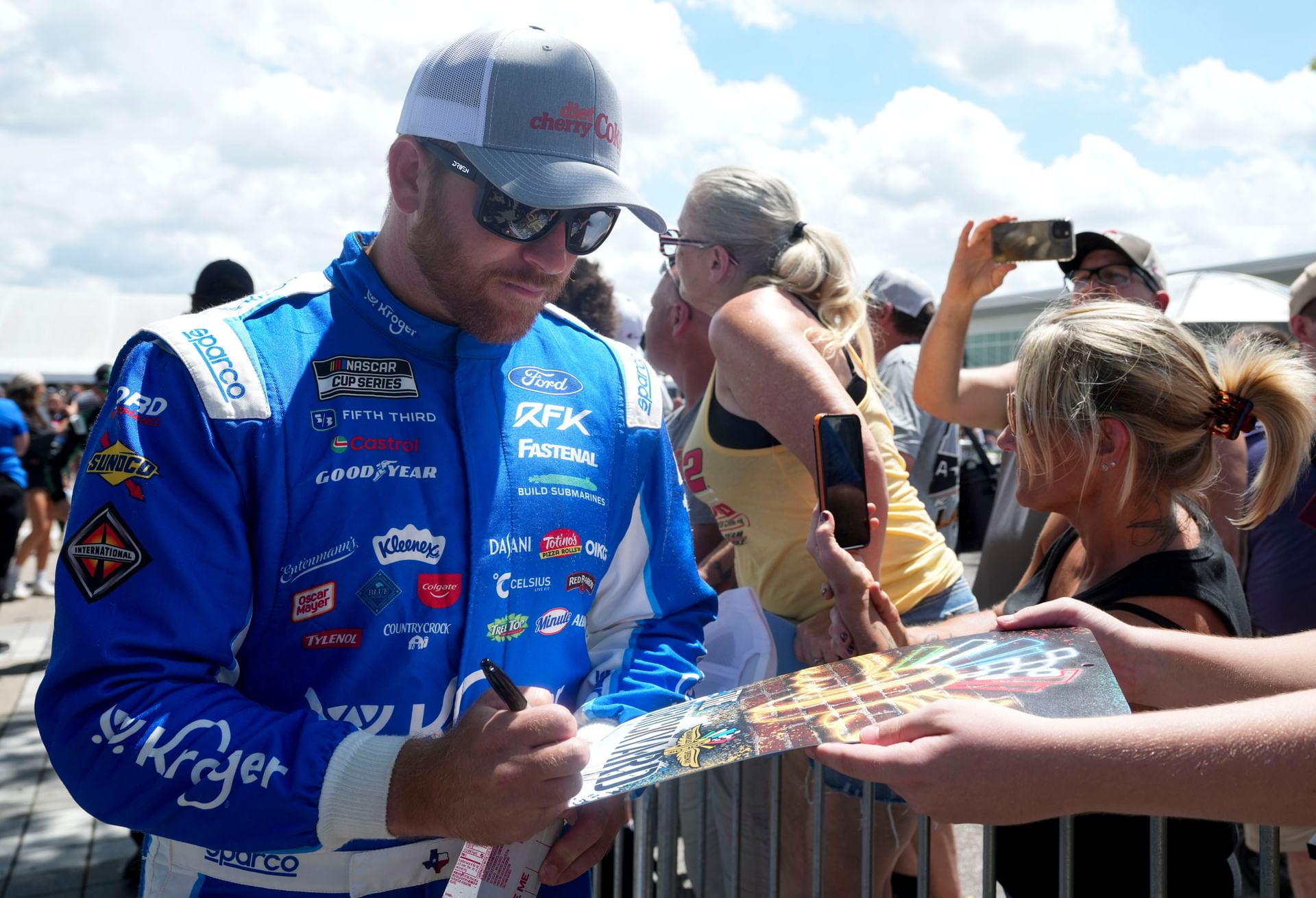 Chris Buescher signs autographs for fans before the Brickyard 400. Source: Imagn