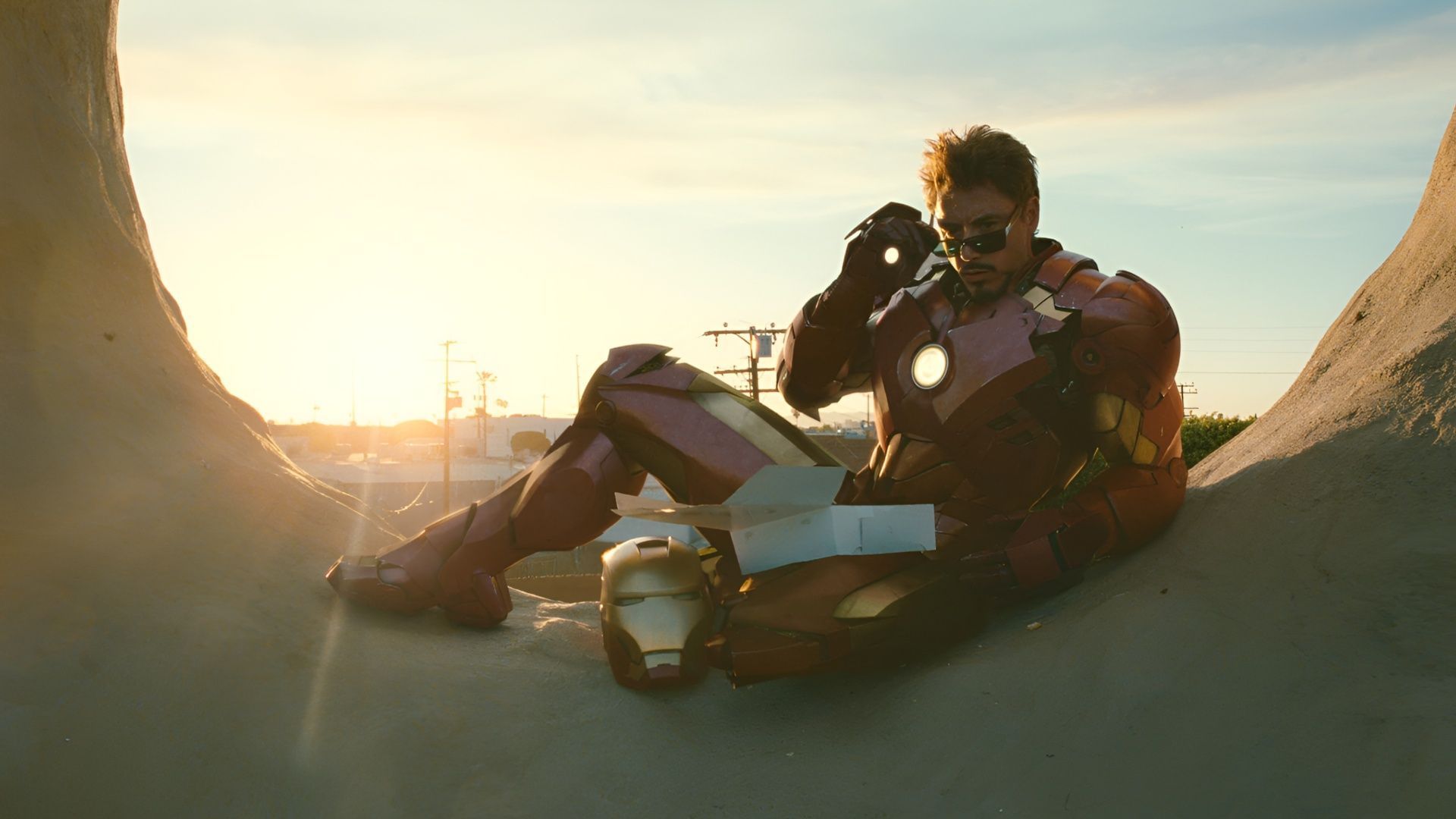 Robert Downey Jr. as Tony Stark in Iron Man 2, wearing the Iron Man suit and sunglasses during a sunset scene. (Image via Disney+)