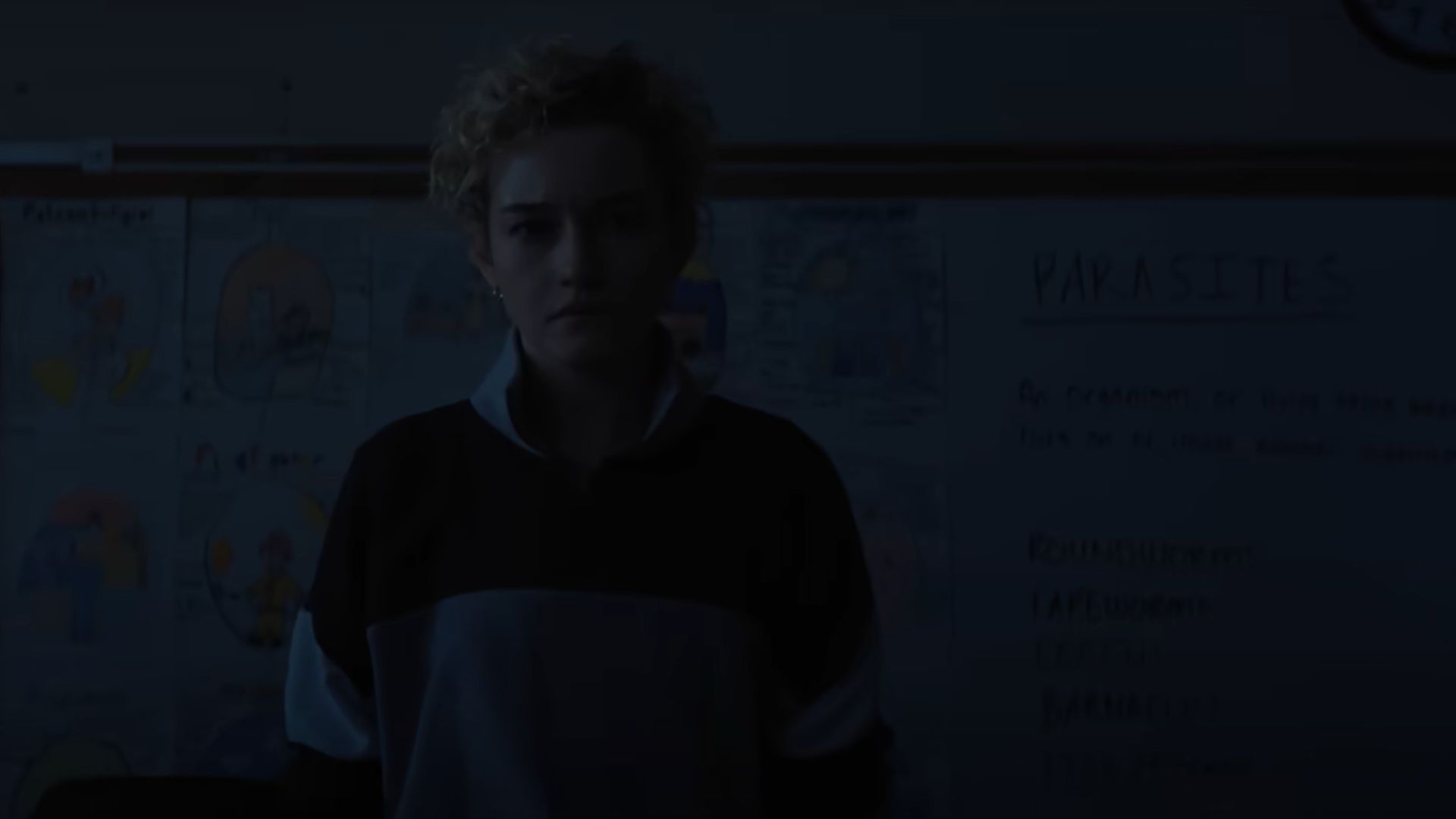 Fans can see the board at the back talking about parasites (Image via YouTube/Warner Bros.)