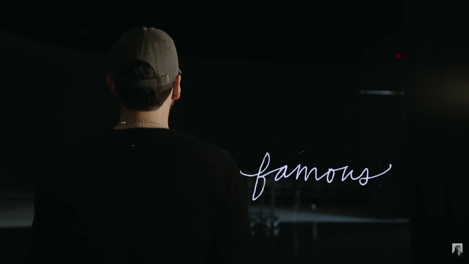A still from Stans (2025) showing Eminem facing the word &quot;famous&quot; onscreen (Image via EminemMusic)