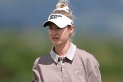 Nelly Korda poses in an orange top as she smiles despite feeling the heat