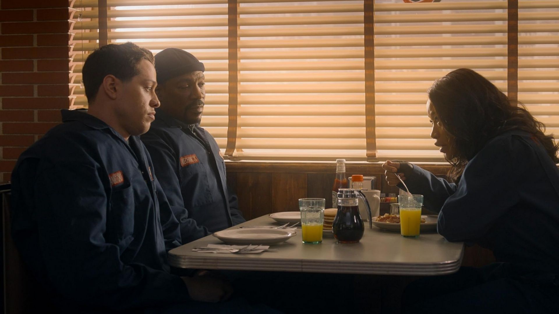 Travis, Russell, and Zoe discuss their plans over breakfast at a diner. (Image via Amazon Prime)