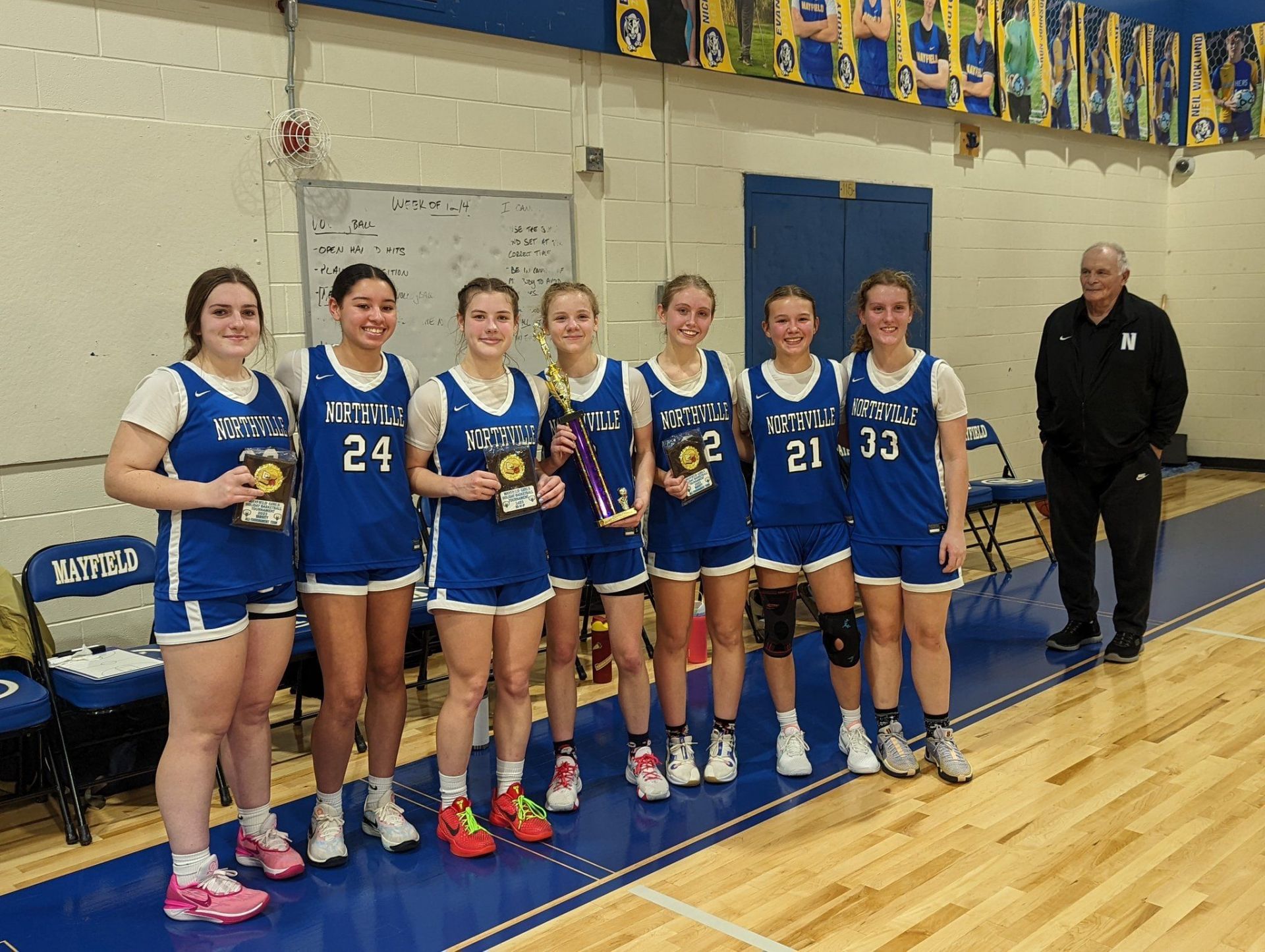 Hailey Monroe with her Northville teammates and former coach Jim Zullo on X. Image via @NCSFalcons 