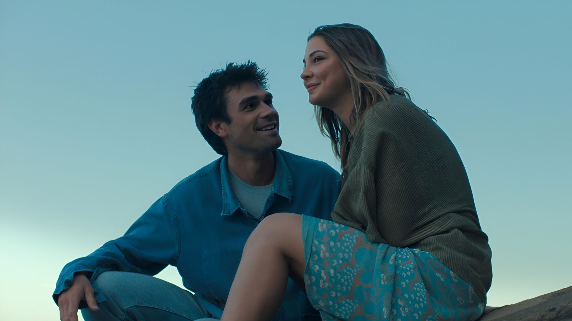 Jack looks at Heather with admiration as they sit outdoors, underscoring their fragile bond.