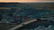 A scene from East of Wall showing vehicles driving through the rugged formations of Badlands National Park during sunset (Image via Sony Pictures)