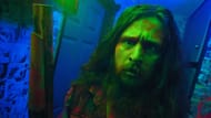 Jimmy faces paranoia in neon light. (Image via YouTube/The Horror Section)