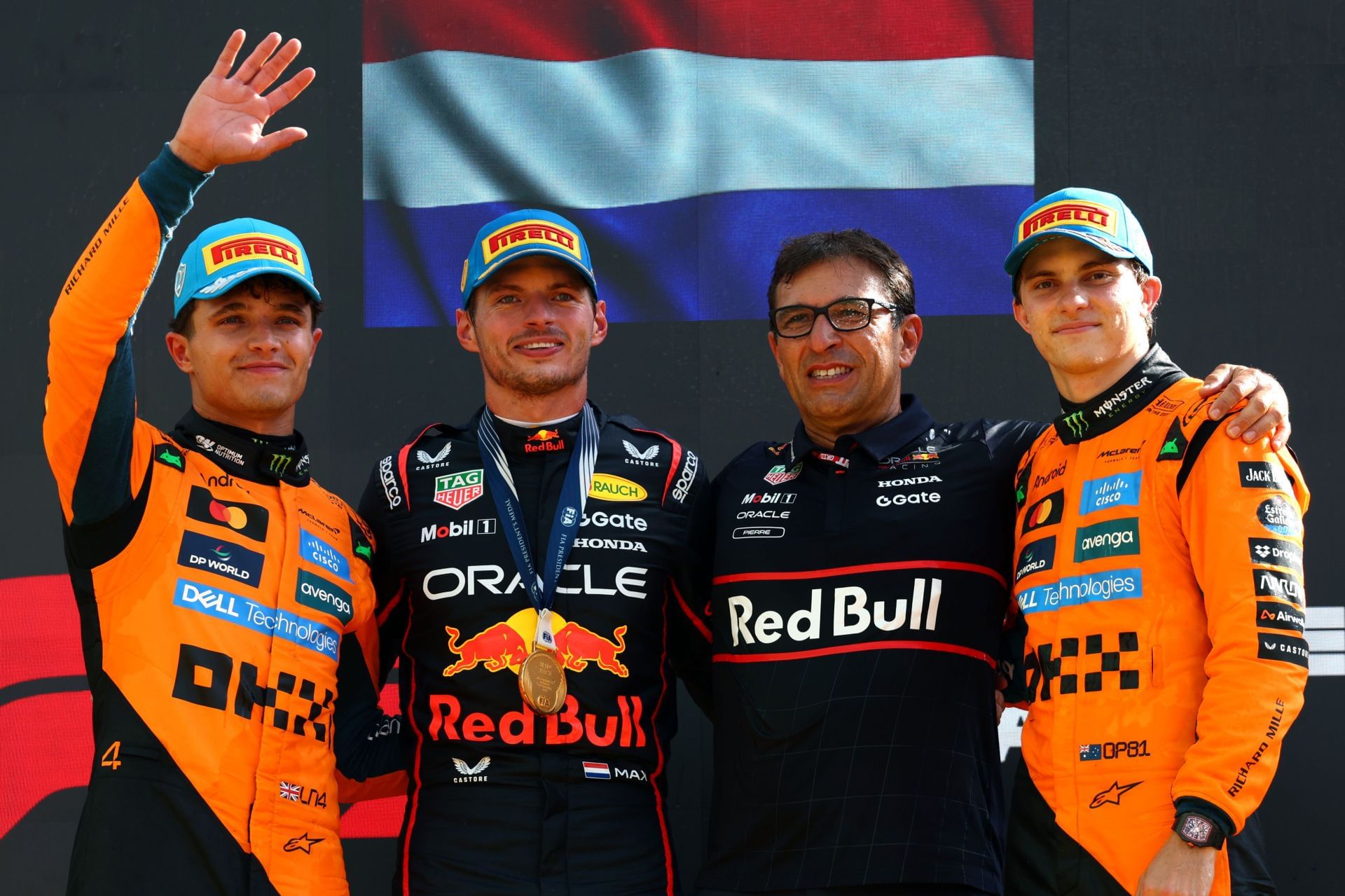 Lando Norris (L), Max Verstappen, Pierre Wache, and Oscar Piastri (R) standing on top of the podium for the 2025 F1 Grand Prix of Italy - Source: Getty