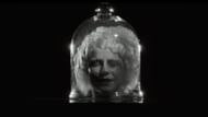 The teaser shows Jessie Buckley’s bride encased in glass, a haunting moment from Maggie Gyllenhaal’s The Bride (Image via YouTube/Warner Bros.)