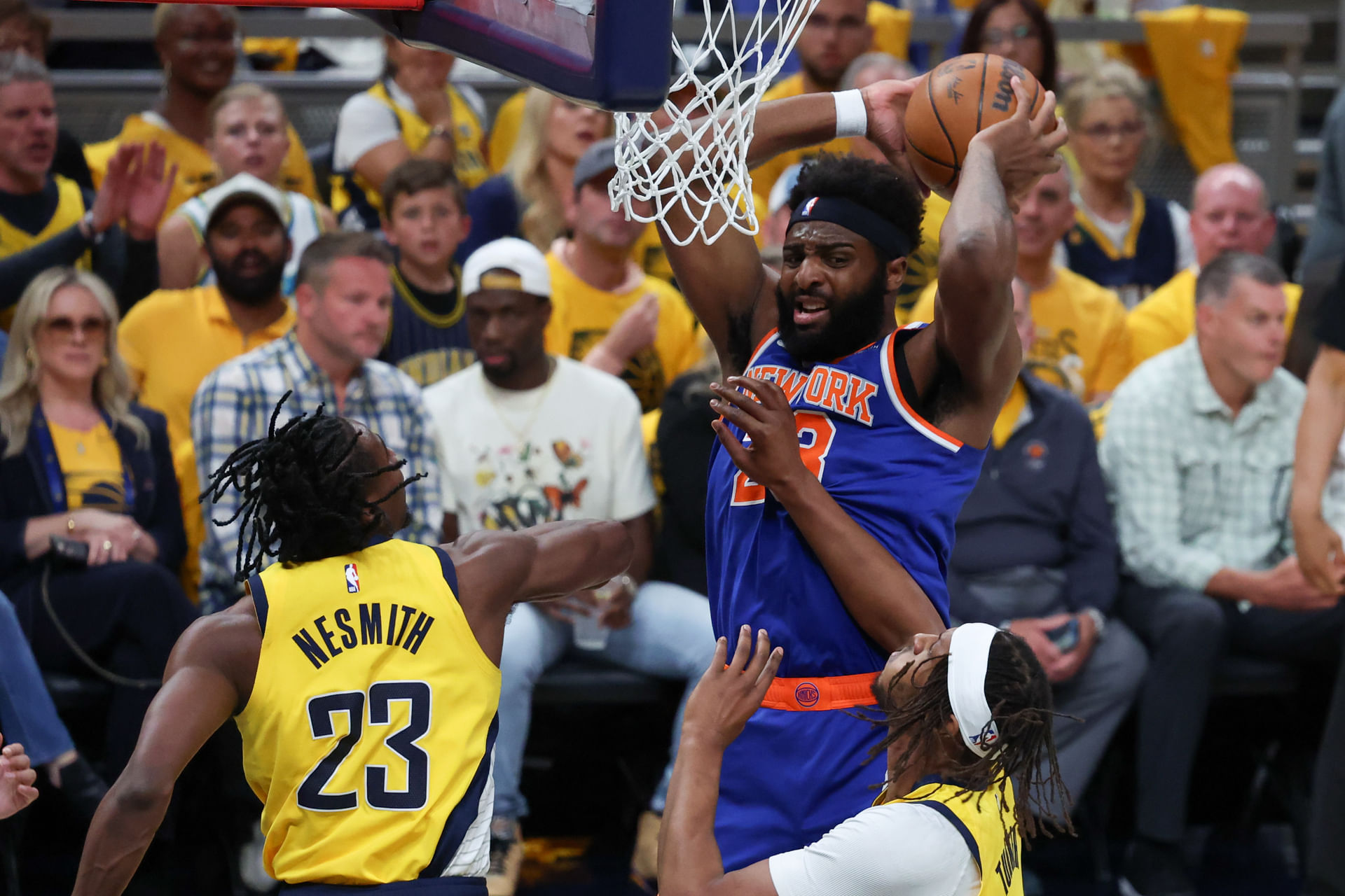 Mitchell Robinson (23) has the ball defended by Indiana Pacers forward Aaron Nesmith (23) and center Myles Turner (33) in the first quarter during game six of the Eastern Conference Finals for the 2025 NBA Playoffs at Gainbridge Fieldhouse. Mandatory Credit: Trevor Ruszkowski-Imagn Images