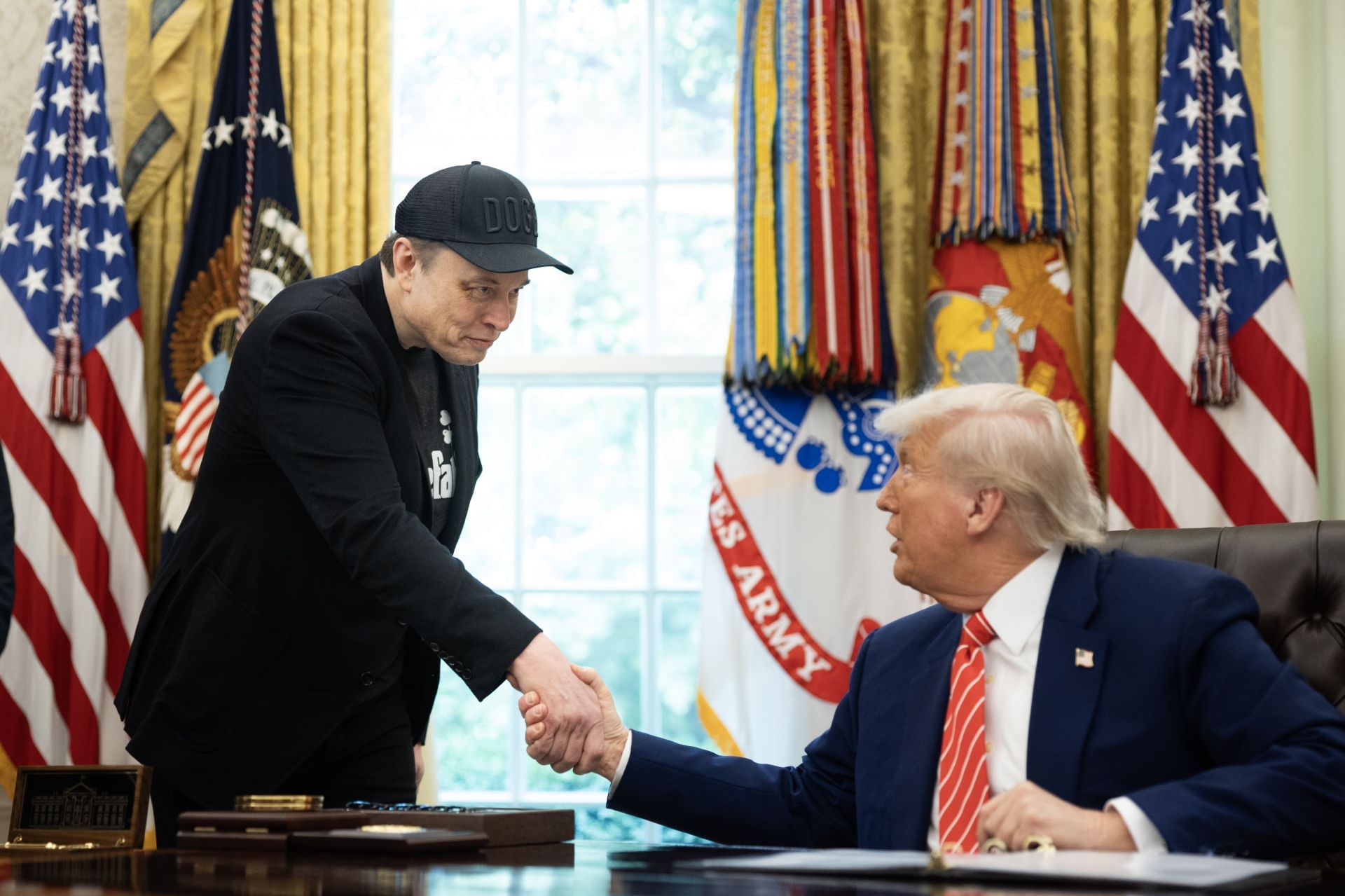 Elon Musk shakes the hand of President Trump inside the White House (Image via Getty)