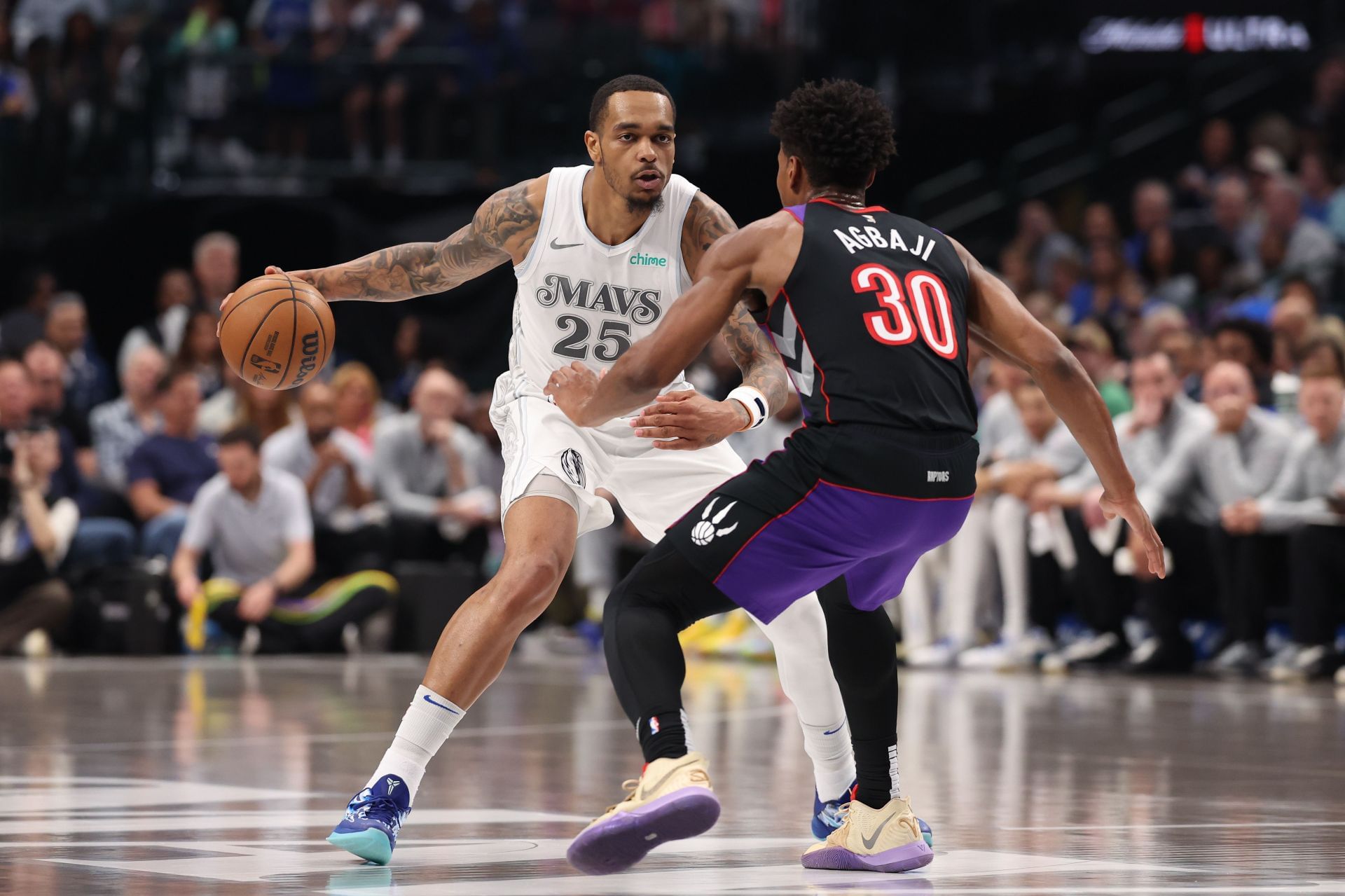 PJ Washington #25 of the Dallas Mavericks is defended by Ochai Agbaji #30 of the Toronto Raptors during the first half at American Airlines Center on April 11, 2025 in Dallas, Texas. - Source: Getty