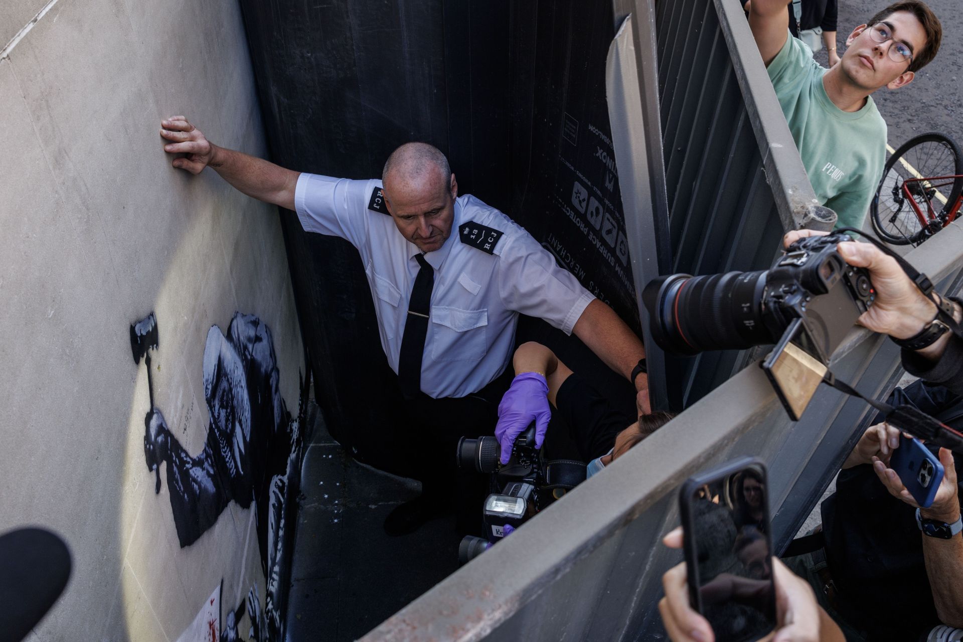 The Banksy mural covered and guarded at The Royal Courts of Justice (Image via Getty Images)