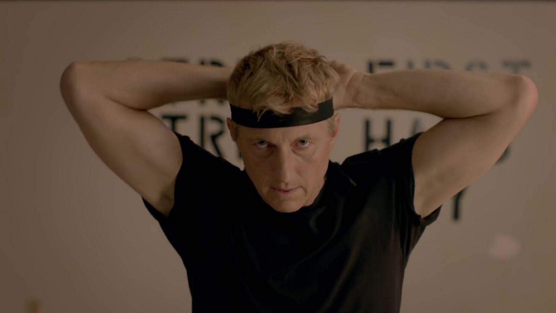 Johnny Lawrence ties his headband, preparing for action in Karate Kid: Legends cameo appearance.