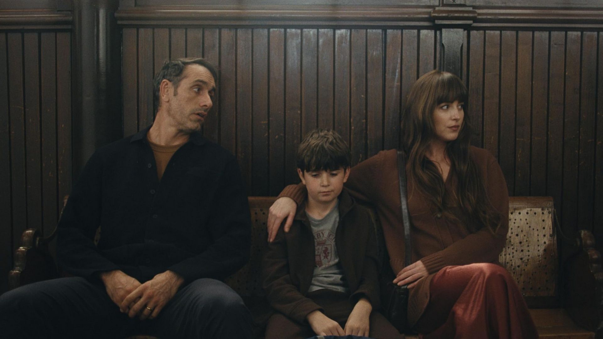 Paul, Julie, and their son Rus sit in a wooden bench area in Splitsville (2025).