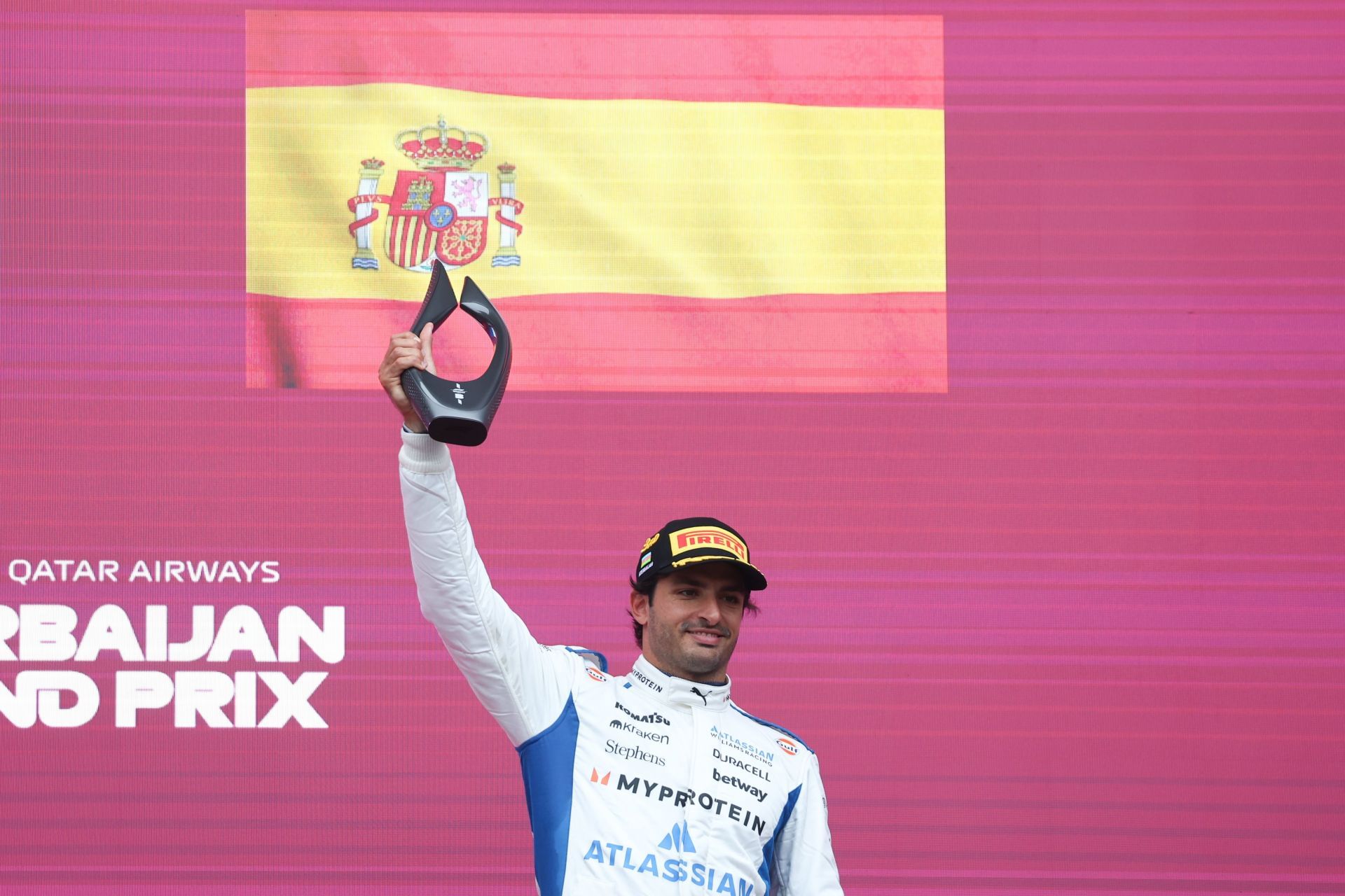 Williams&#039; Carlos Sainz holding the third-place trophy on the podium after the F1 Grand Prix of Azerbaijan 2025 - Source: Getty