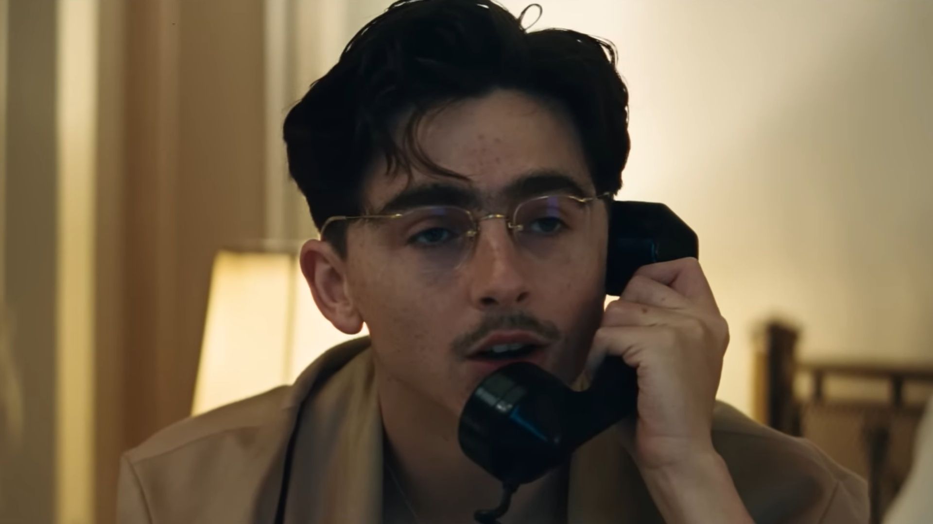 Marty Supreme still: close-up of a character speaking on the phone. (Image via A24)