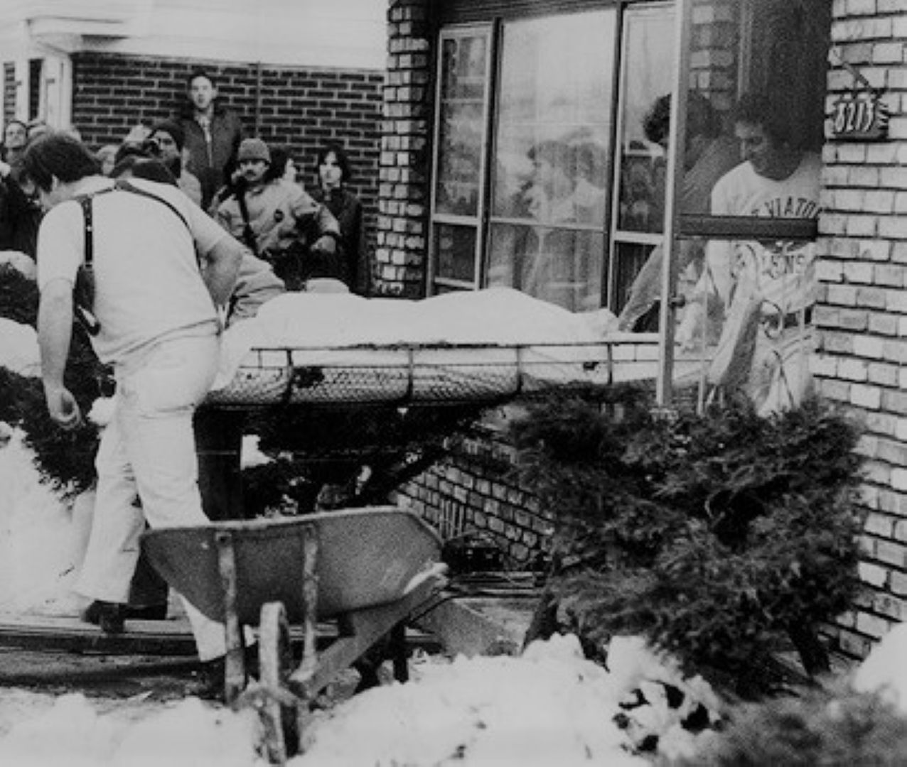 Medical examiners retrieve one of the first bodies exhumed from beneath Gacy&#039;s crawl space. December 23, 1978. (Image via Wikimedia Commons)