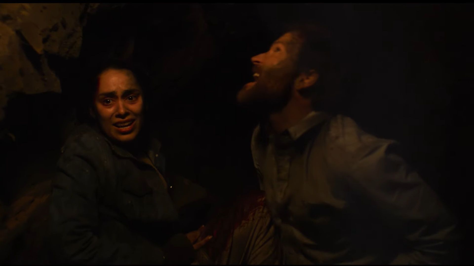 Emalia (as Kate) and Jamie Costa (as Mark) in a tense scene from Scurry, injured and terrified inside a dark, collapsing tunnel.