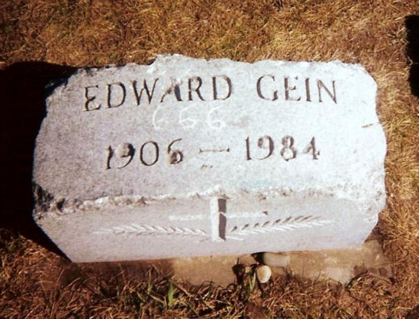 Gein&#039;s vandalized grave marker as it appeared in 1999, before thieves stole it. (Image via Wikimedia Commons)