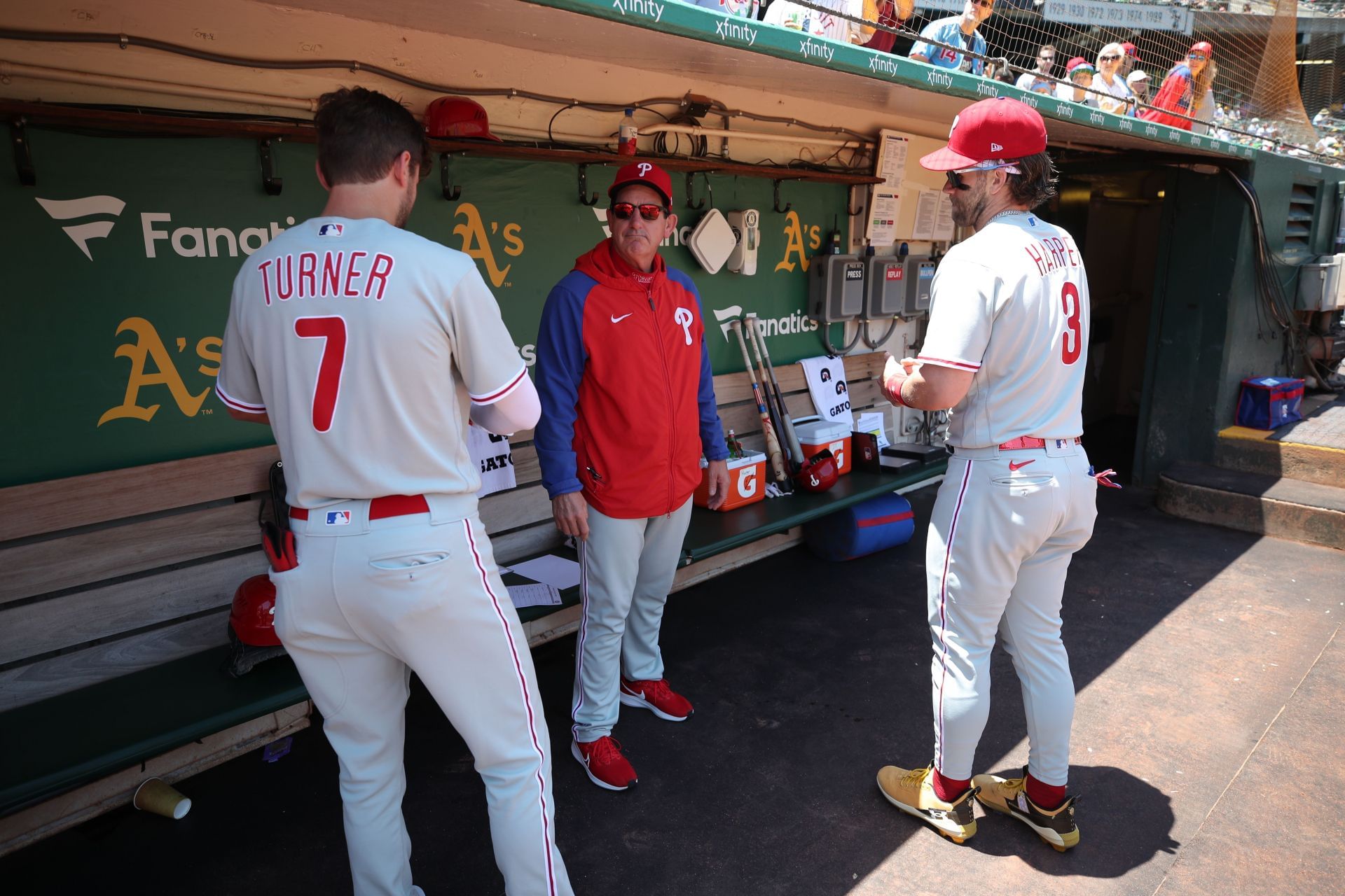 Trea Turner and Bryce Harper talk to Rob Thomson in the dugout - Source: Getty