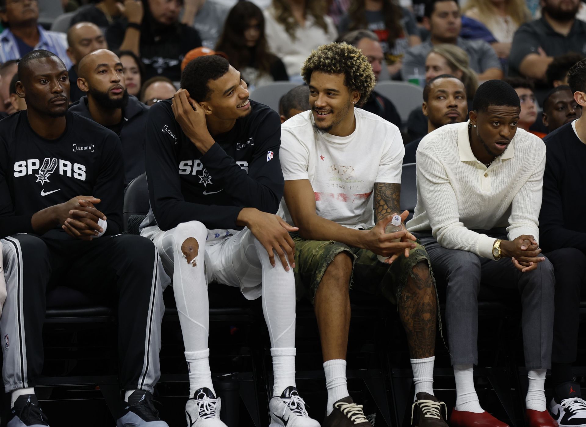 Victor Wembanyama #1 of the San Antonio Spurs jokes with teammates in the first half of in a pre-season game against he Guangzhou Loong-Lions at Frost Bank Center on October 6, 2025 in San Antonio, Texas. - Source: Getty