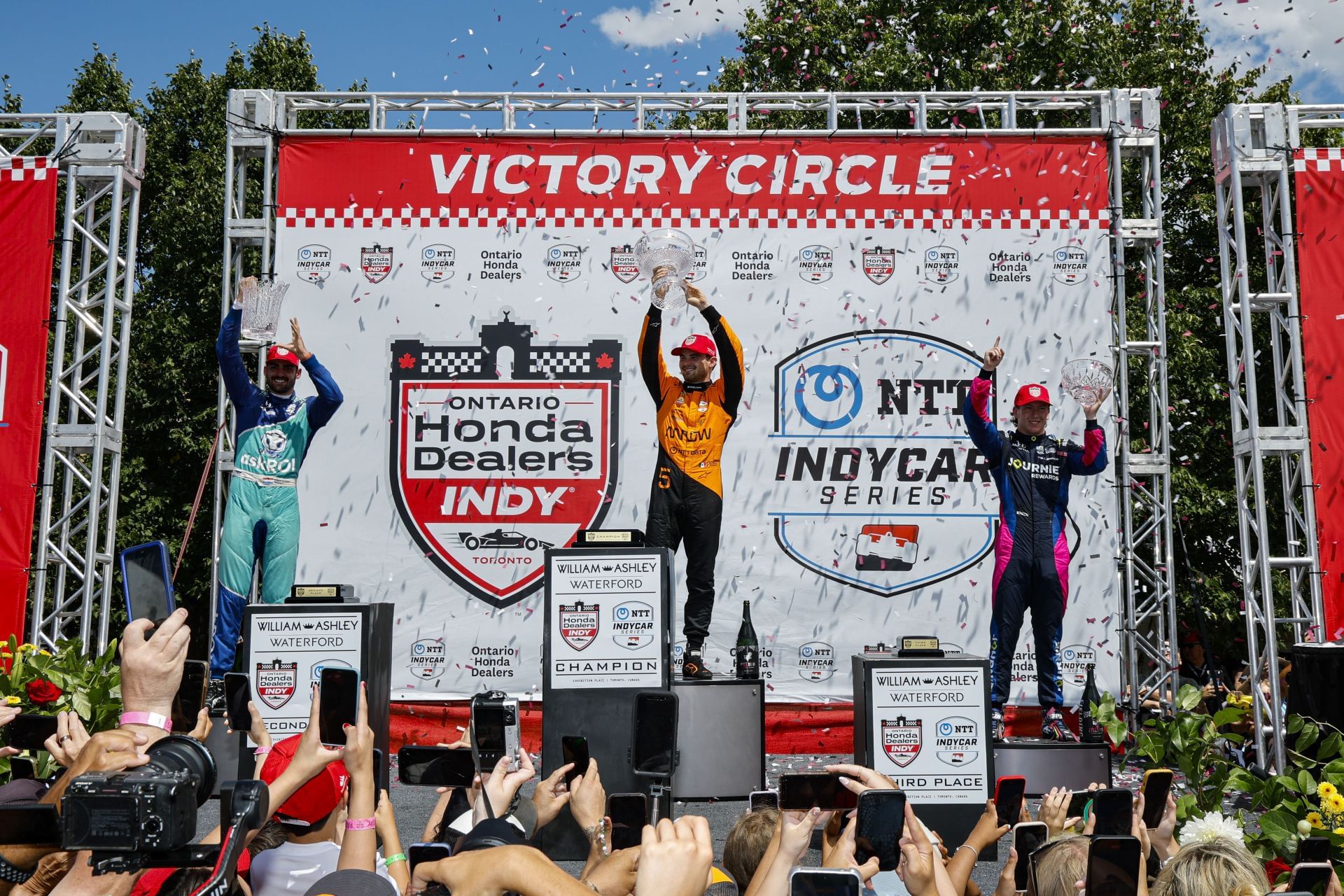 Rinus Veekay on the podium with Pato O&#039;Ward and Kyffin Simpson at the NTT INDYCAR Series Ontario Honda Dealers Indy Toronto - Source: Getty