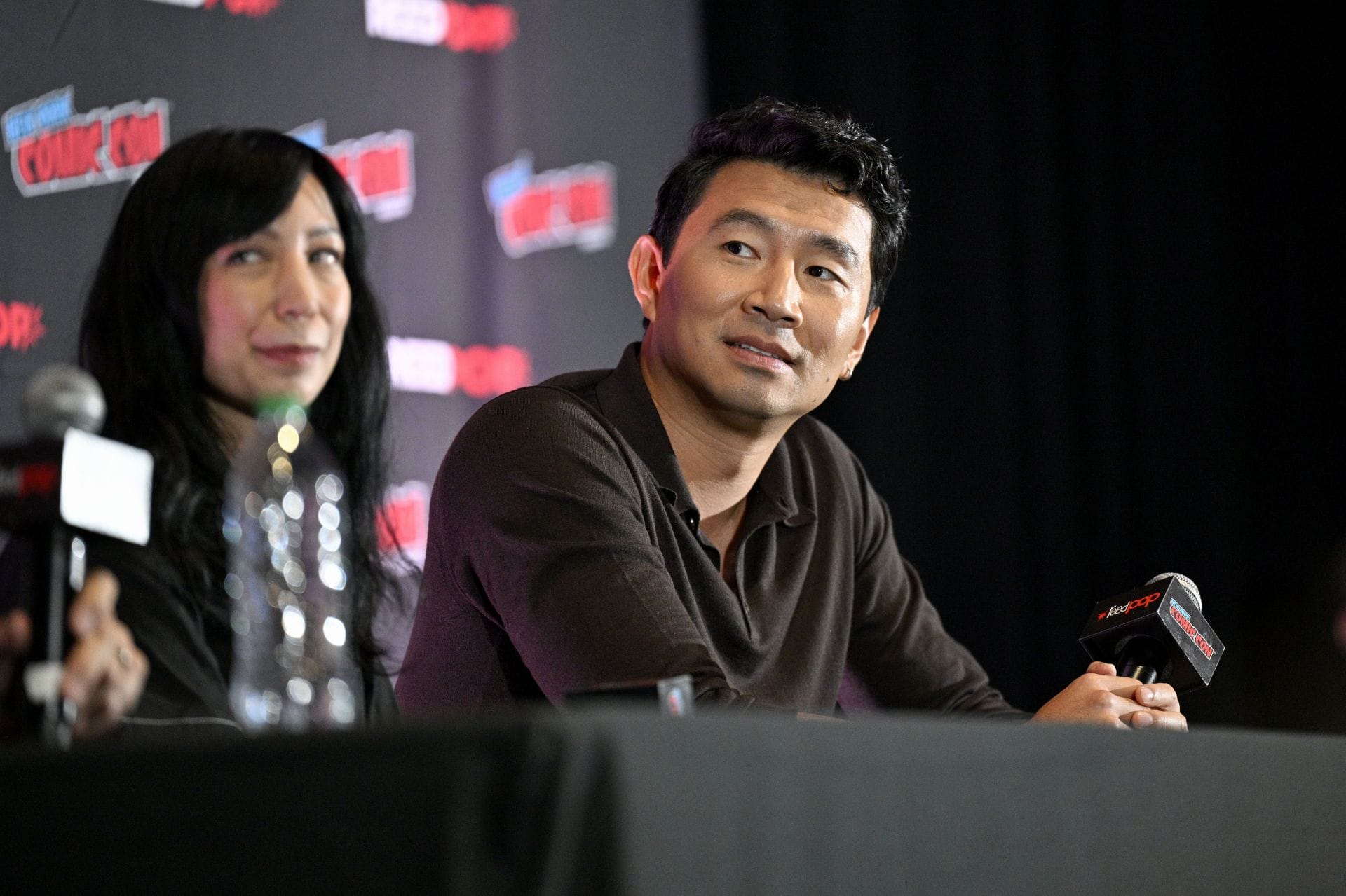 Simu Liu mluví na jevišti na First Look v Peacockově špionážně-thrillerové sérii- The Copenhagen Test během New York Comic Con 2025 (obrázek přes Getty)