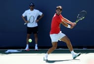 Carlos Alcaraz (in front) prepares to hit a backhand with coach Juan Carlos Ferrero (standing behind) looking on during a practice session at the 2025 US Open (Source: Getty)
