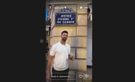 Novak Djokovic poses in front of a Serbian street sign in Paris