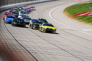 Carson Hocevar (77) lidera Tyler Reddick (45) durante a primeira etapa da corrida FireKeepers Casino 400 NASCAR Cup Series no Michigan International Speedway. Fonte: Imagem