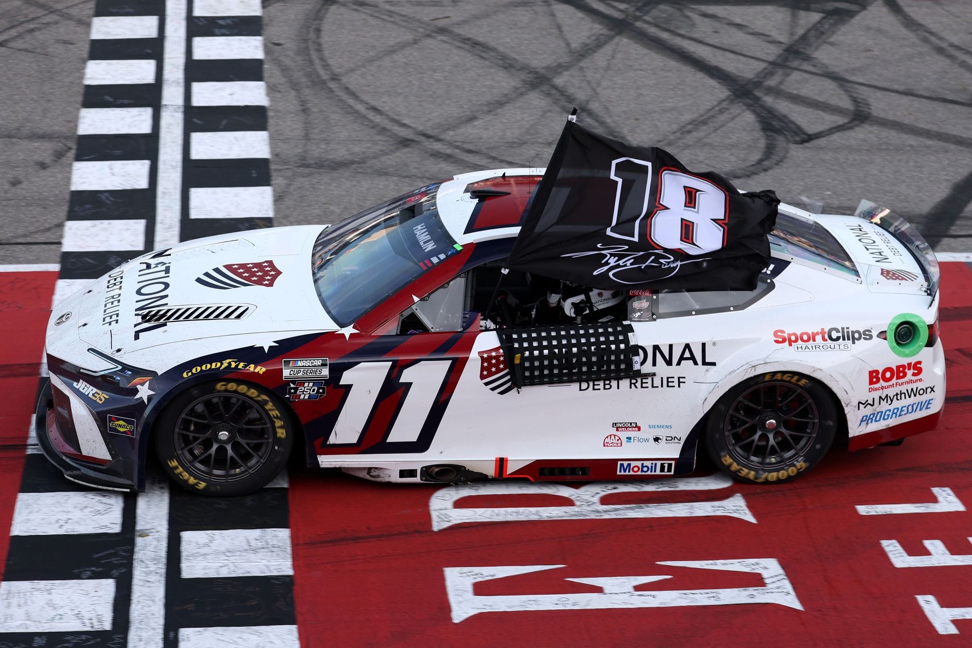 Watch: Denny Hamlin honors Kyle Busch with emotional ‘18’ flag tribute as he goes from last to first at Michigan